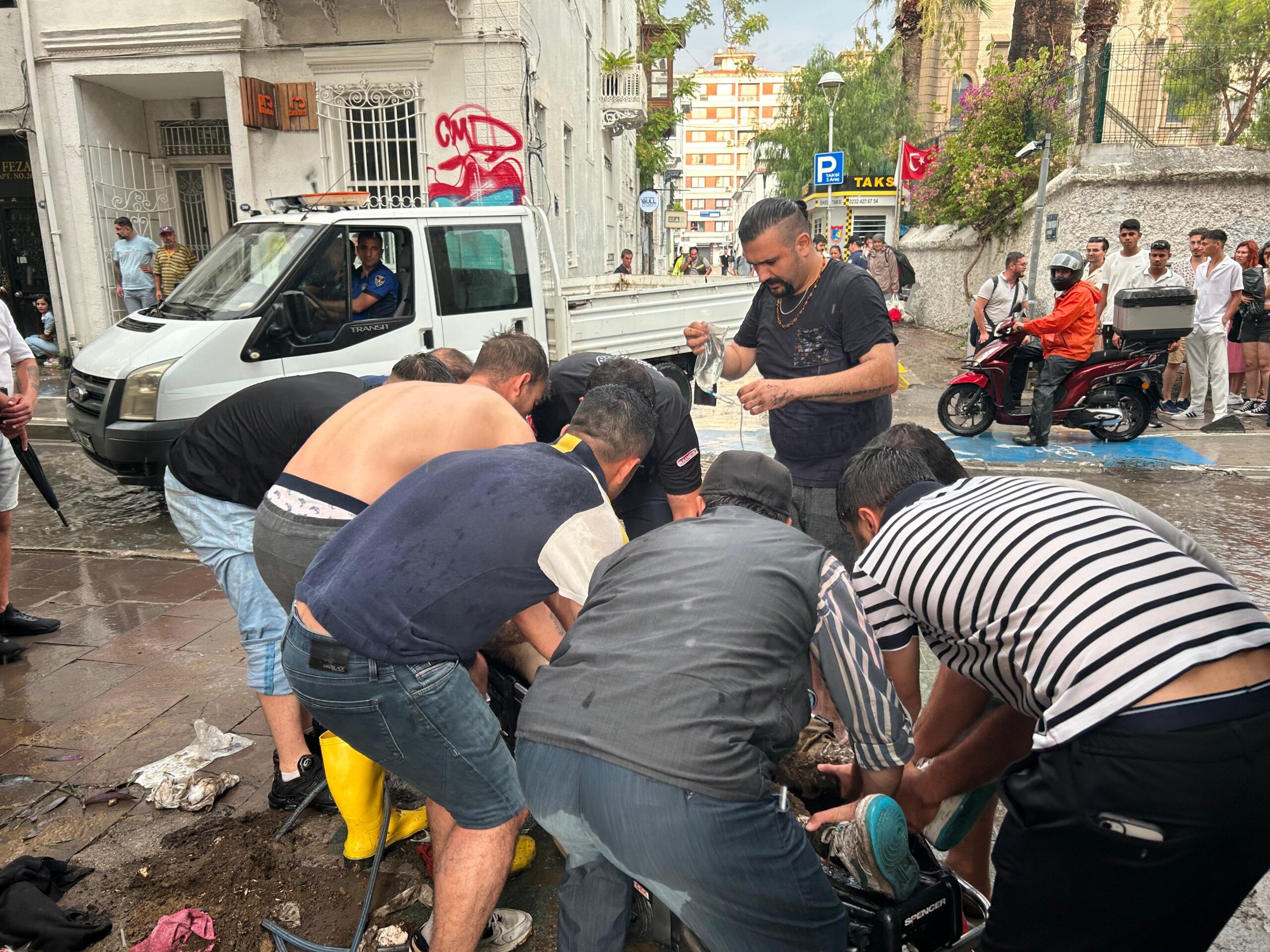 İzmir’in Konak ilçesinde, yoğun yağmur sırasında yoldaki su birikintisinden karşıdan