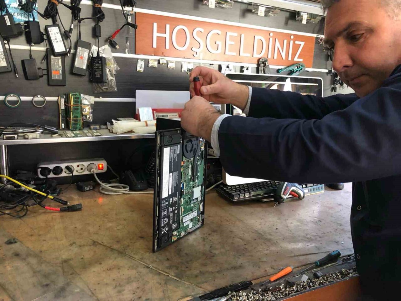 Eskişehirli esnaf İsmail Demirkapı, insanların teknolojik cihazlarını tamir etmeye çalışırken