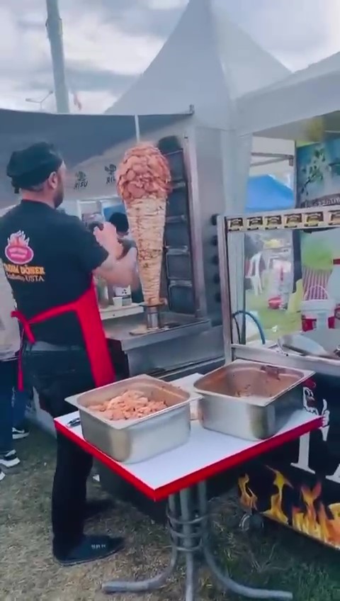 Adana'da karnavalda bir dönercinin daha pişmiş tavuğun üzerine çiğ tavuk