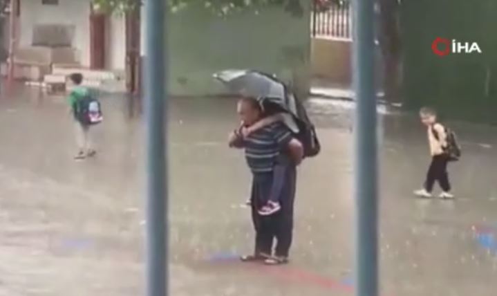 Adana’da ismi öğrenilemeyen dede, yağmur altında torununu sırtına alıp, İstiklal