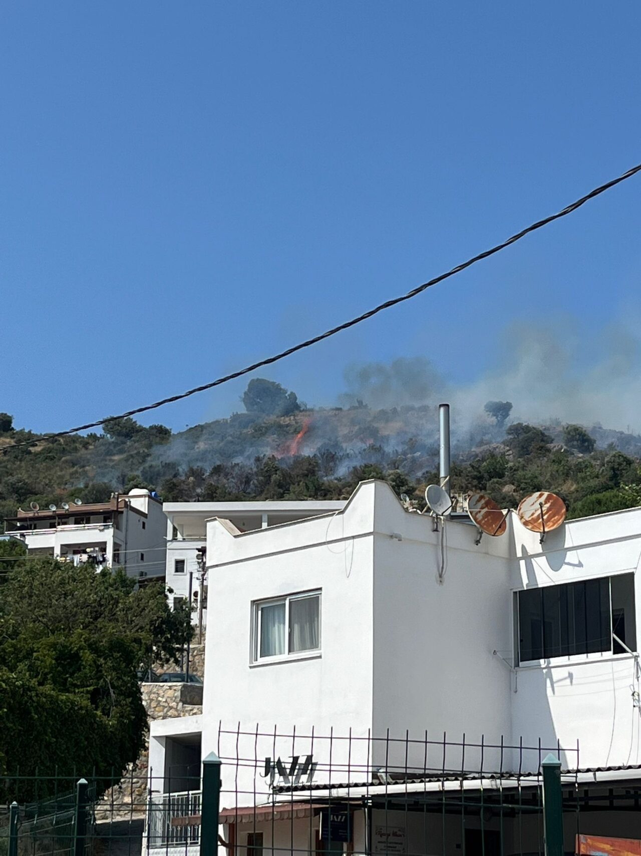 Muğla'nın Bodrum ilçesinde makilik alanda çıkan yangın havadan ve karadan