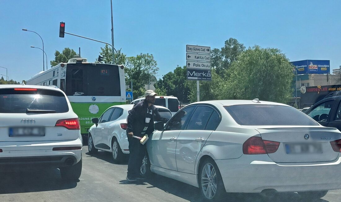 Adana'nın işlek caddelerinde, kırmızı ışıkta duran araçların camlarını izinsiz bir
