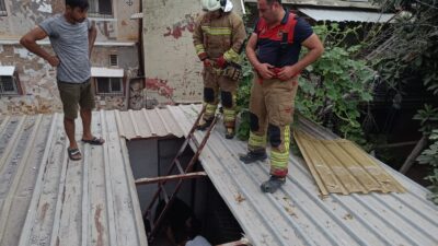 Hatay'ın İskenderun ilçesinde, bir yapının demir saç çatısı üzerinde yürüyen