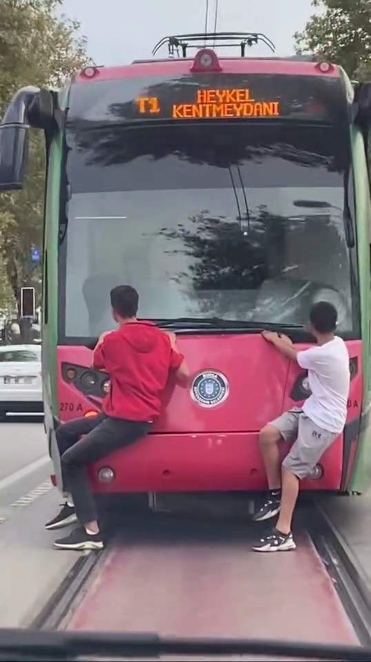 Bursa’nın Osmangazi ilçesinde iki çocuk, seyir halindeki tramvayın arkasına tutunarak