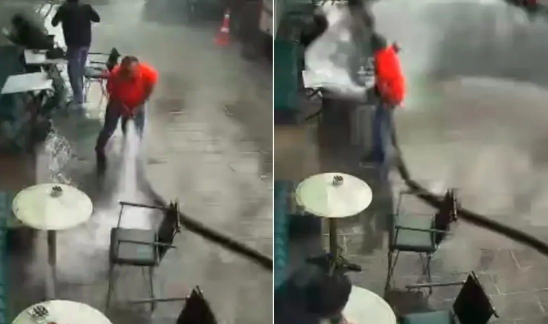 Bir kafe işletmecisi, iş yerinin önünü tazyikli suyla yıkamak isterken