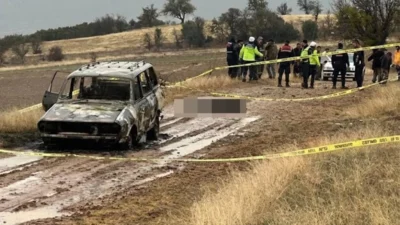 Isparta'da dağlık alanda yanmış bir aracın yakınında, baş kısmı olmayan