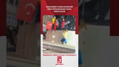 Arkadaşının yukarı çıkması için eğilip sırtını basamak yapan küçük çocuk…